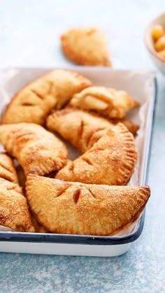 several pastries are arranged in a baking dish on a table with other food items