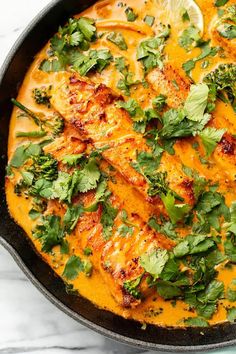 a skillet filled with chicken and cilantro sauce