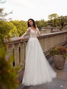 a woman in a wedding dress standing on a balcony