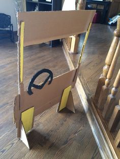 an open cardboard box sitting on top of a wooden floor next to a stair case