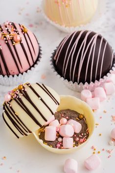 three cupcakes with chocolate and marshmallow toppings on the top one is in a bowl