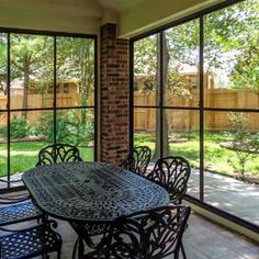 an enclosed patio with table, chairs and sliding glass doors leading to the back yard