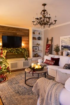 a living room filled with furniture and a christmas tree in front of a tv mounted on the wall