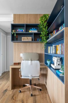 a home office with blue shelving and bookshelves on the wall, along with a white chair