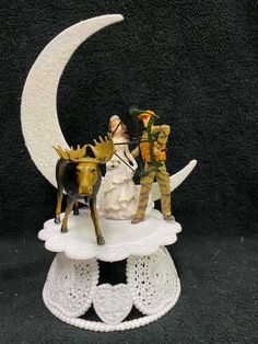 two figurines are standing on top of the moon