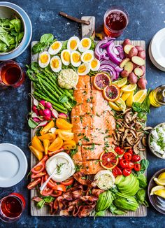 an assortment of food is laid out on a cutting board and ready to be served