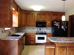 a kitchen with wooden cabinets and marble counter tops