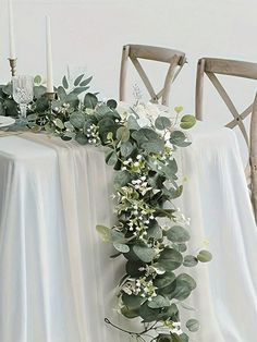 the table is decorated with greenery and candles