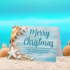 a merry christmas card on the beach with starfish and seashells