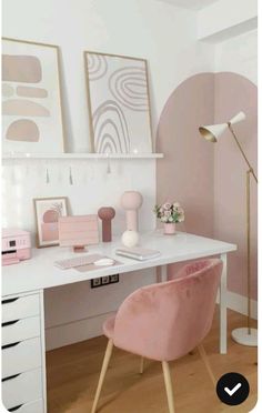 a white desk topped with a pink chair next to a lamp and pictures on the wall