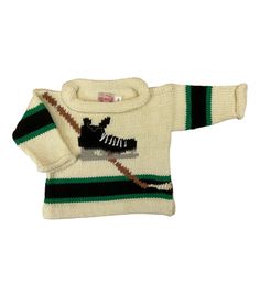 ivory long sleeve sweater with black band on waist and arms with green trim and hockey skate/stick in center Classic Hand Knitted Sweater For Winter, Hand Knitted Cotton Sweater For Fall, White Wool Sweater With Knitting Details, Vintage Cream Knit Sweater, Fitted Hand Knitted Cotton Sweater, Fitted Hand-knitted Cotton Sweater, Retro Cream Knit Sweater, Hand Knitted Vintage Knit Sweater, Vintage Hand-knitted Sweater