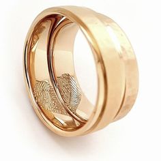 two gold wedding rings with fingerprints on each side and one in the middle