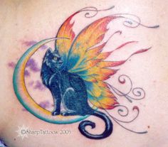 a woman's back with a cat and butterfly tattoo on it