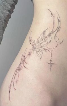 a woman's thigh with a cross and flower tattoo on her lower back side