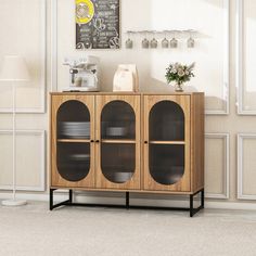 a wooden cabinet with metal mesh doors in a living room next to a white wall