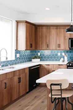 a kitchen with wooden cabinets and white counter tops, black appliances and an island in the middle