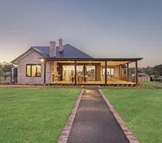 a house that is in the grass with a walkway leading up to it's front door