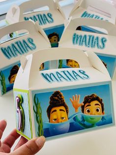 a hand holding up a box with some cartoon characters on the front and back of it