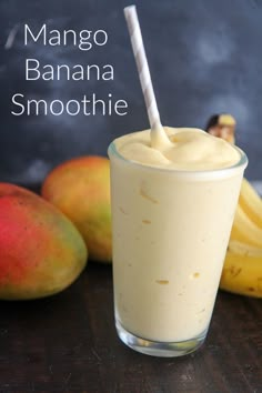 mango banana smoothie in a tall glass with a straw sticking out of the top