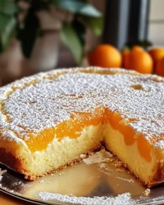 a cake that has been cut into pieces and is sitting on a plate with some oranges in the background