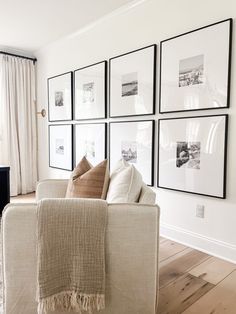 a living room filled with furniture and framed pictures on the wall above it's couch