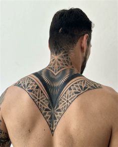 the back of a man with tattoos on his upper and lower part of his body