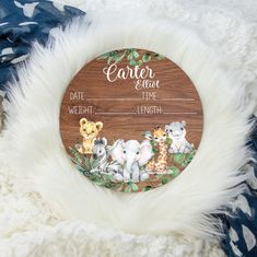 a wooden sign with animals on it sitting on top of a white fur covered blanket