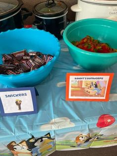 a table topped with blue bowls filled with candy and other items on top of it