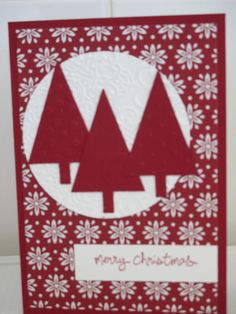 a red and white christmas card with snowflakes on the bottom, and trees in the middle