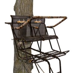 two hunting chairs sitting next to a tree