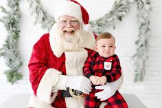 a baby is sitting on santa claus's lap