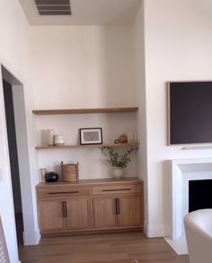 a living room filled with furniture and a flat screen tv mounted on the wall above a fireplace