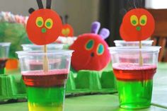 two cups filled with liquid sitting on top of a green table covered in red and yellow decorations