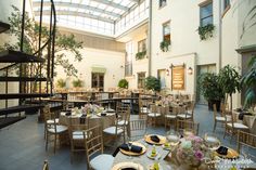 an indoor dining area with tables, chairs and planters on the floor in front of it