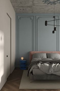 a bed sitting in the middle of a bedroom next to a wall with blue paint