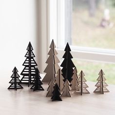 small black and white christmas trees sitting on top of a table next to a window