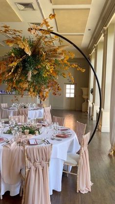 a round table with white linens and pink sashes is set up for a formal function