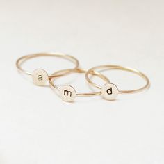 One gold letter ring. Personalize a gift she'll treasure with our gold initial ring. An adorably petite initial, imprinted on a 14k gold filled disk - paired with a super skinny (1mm) gold filled band - creates the perfect stacking ring, customized with your monogram. Lovely as a stand alone. Also sits beautifully with multiple initials stacked or our hammered gold stacking ring bands. This gold initial ring arrives custom made to order in your size hand stamped with the letter of your choice. A Gold Stackable Rings With Initials For Everyday, Everyday Gold Stackable Rings With Initials, Everyday Stackable Yellow Gold Rings With Initials, Personalized Yellow Gold Initial Ring For Everyday, 14k Gold Stackable Rings With Initials, Minimalist Yellow Gold Stackable Rings With Initials, Everyday Personalized Yellow Gold Initial Ring, Dainty Gold Stackable Rings With Initials, Simple Stackable Initial Ring