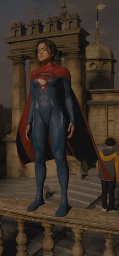 a man in a superman suit standing next to a statue