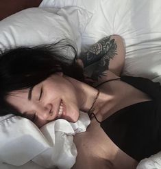 a woman laying in bed with her eyes closed