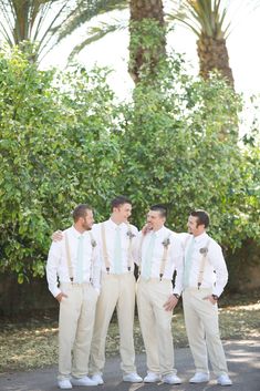 three men in white shirts and green ties standing next to each other with their arms around one another