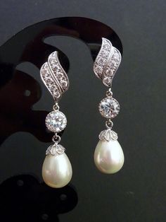 a pair of pearl and diamond earrings