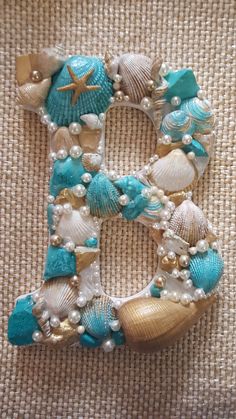 the letter e is made out of seashells, pearls and other sea creatures