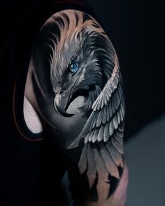 a man with a tattoo on his arm that has an eagle and blue eyes in it