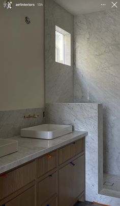 a bathroom with marble counter tops and wooden cabinets