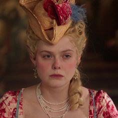 a woman with blonde hair wearing a red and white dress is looking at the camera