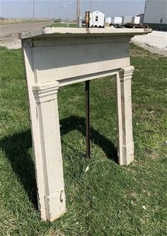 an old white table sitting in the grass