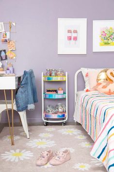 a bedroom with purple walls and colorful accessories on the shelf next to the bedspread