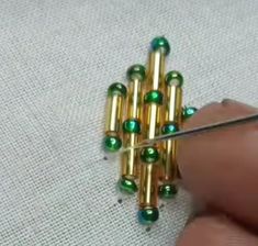 someone is working with some beads on a piece of fabric