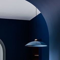 a room with blue walls and a white ceiling light hanging from the ceiling above it